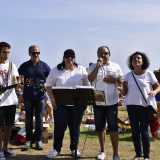 Ma ecco che parte lo �spettacolo�. Si comincia con la musica. Un coro accompagnato dalle note di una chitarra attira passanti e bagnanti...